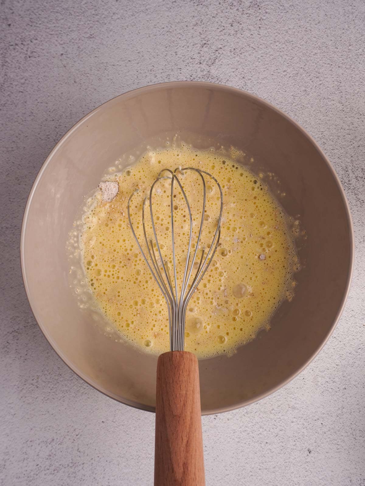 A bowl of whisked wet ingredients.