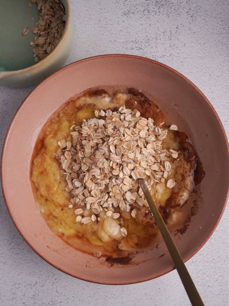 A bowl with oats, egg whites and a mashed banana.